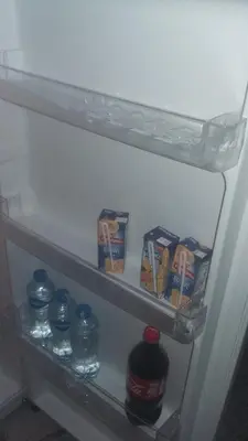 a refrigerator shelf with food and drinks on it at King Nubian House in Aswan