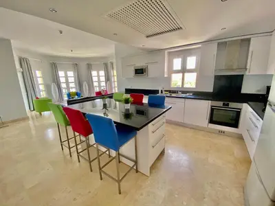 a kitchen with a island with colorful chairs in it at El Gouna Abu Tig Marina OV3550 in Hurghada