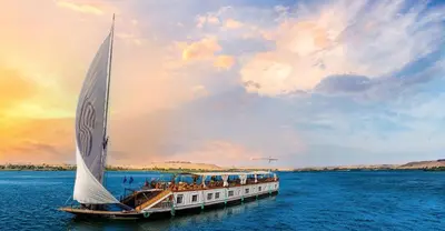 a boat with a large sail in the water at Sonesta Dahabeya Amirat I - Nile Cruise Ship From Luxor to Aswan 7 nights in Luxor