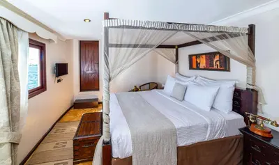 a bedroom with a bed with a canopy at Sonesta Dahabeya Amirat I - Nile Cruise Ship From Luxor to Aswan 7 nights in Luxor