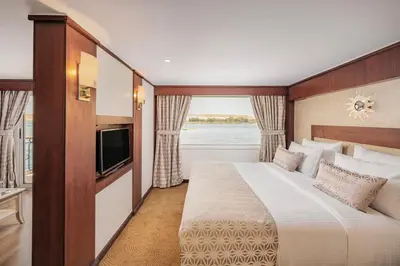 a bedroom with a large bed and a television at Sonesta Star Goddess Cruise - Luxor- Aswan - 04 & 07 nights Each Saturday in Luxor