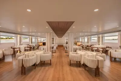 a restaurant with white tables and chairs and windows at Sonesta Star Goddess Cruise - Luxor- Aswan - 04 & 07 nights Each Saturday in Luxor