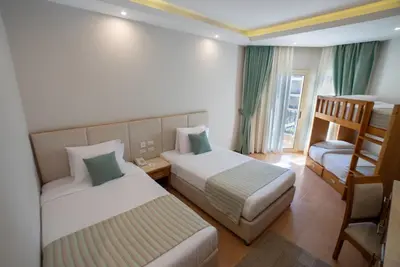 a hotel room with two beds and a chair at Sunrise Aqua Joy Resort in Hurghada