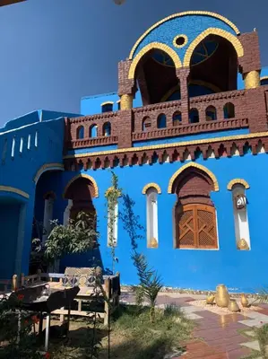a blue building with windows and a bench in front at Golden Palace Garden in Luxor