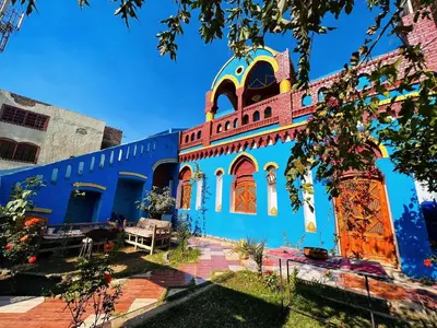 a blue building with orange doors and windows at Golden Palace Garden in Luxor