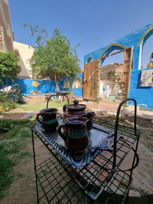 two tea pots on a table in front of a building at Golden Palace Garden in Luxor