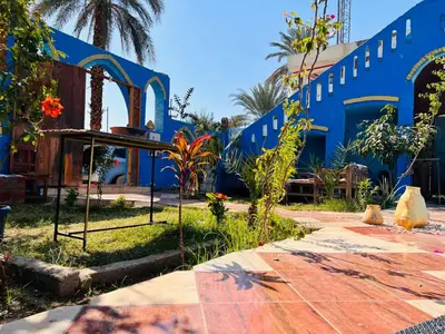 a blue building with a table and some plants at Golden Palace Garden in Luxor