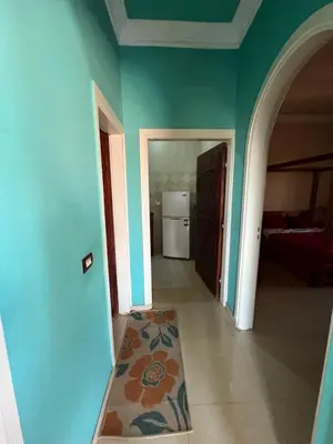 a room with green walls and a hallway with a refrigerator at Harmony House Luxor in Luxor