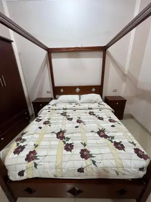 a bed with a floral comforter in a bedroom at Harmony House Luxor in Luxor