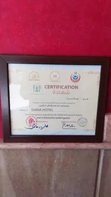 a certificate in a wooden frame on a red wall at Diana Hotel Hurghada in Hurghada