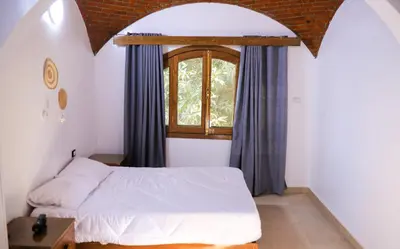 a bedroom with a bed and a window at Nubian Holiday House Aswan in Aswan