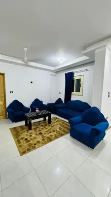 a living room with blue couches and a table at Memnoun house in Luxor