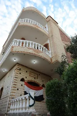 a building with a balcony with a flag on it at Memnoun house in Luxor