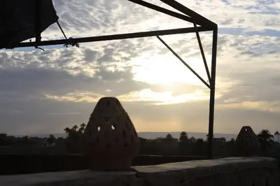 a vase sitting on a table with the sunset in the background at Memnoun house in Luxor