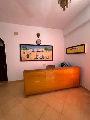 a wooden desk in a room with a clock on the wall at Eka- Guesthouse in Aswan