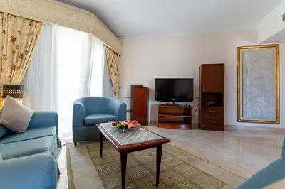 a living room with a couch and a table and a tv at Swiss Inn Resort Hurghada in Hurghada