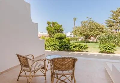 two wicker chairs and a table on a patio at Hurghada Long Beach Resort in Hurghada