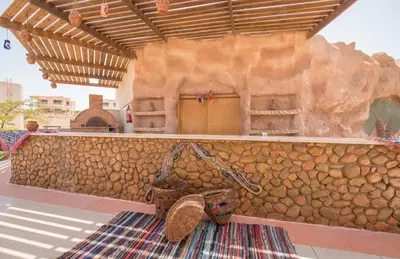 a stone wall with a wicker basket next to a rug at Hurghada Long Beach Resort in Hurghada