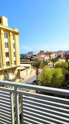 a balcony with a white fence and a building at Magic Beach Hotel Hurghada in Hurghada