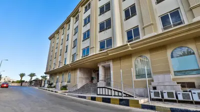 a building on a street next to a road at Magic Beach Hotel Hurghada in Hurghada
