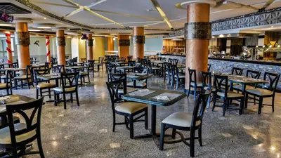 a restaurant with tables and chairs and a bar at Magic Beach Hotel Hurghada in Hurghada