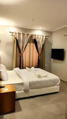 a bedroom with a large white bed with curtains at Magic Beach Hotel Hurghada in Hurghada