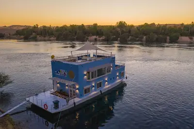 a blue boat in the middle of a river at Anakob in Aswan