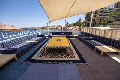 a cafeteria with a yellow table and benches at Anakob in Aswan