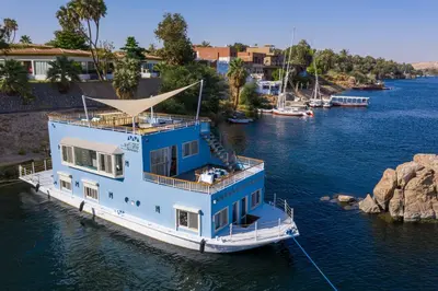a blue boat is docked in the water at Anakob in Aswan