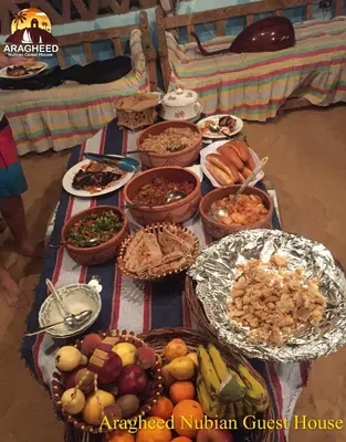 a table filled with different types of food at Nubian Kingdom Aragheed House in Aswan
