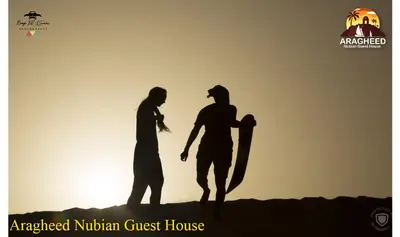 a group of three people standing in front of the sunset at Nubian Kingdom Aragheed House in Aswan