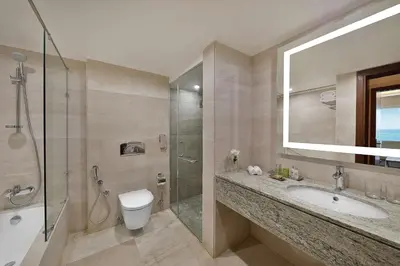 a bathroom with a sink and a shower and a toilet at Hilton Hurghada Plaza Hotel in Hurghada