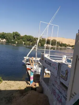 a person standing on the side of a boat in the water at Otasho Nile view house in Aswan