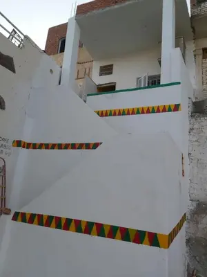 a white building with a banner in front of it at Otasho Nile view house in Aswan
