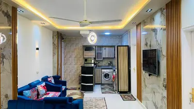 a living room with a blue couch and a kitchen at Apartment in Center of Hurghada in Hurghada