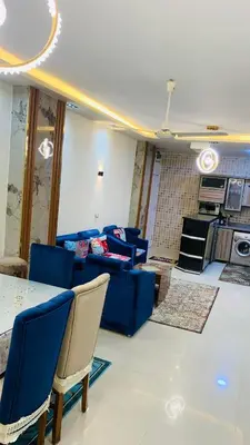 a living room with blue chairs and a table at Apartment in Center of Hurghada in Hurghada
