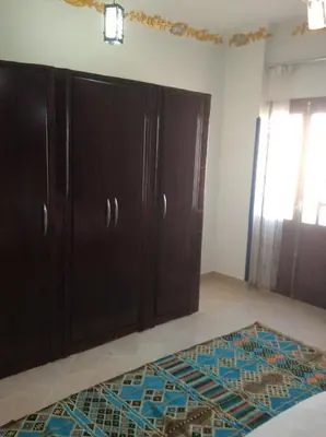 a room with wooden cabinets and a rug on the floor at The Brown House in Luxor