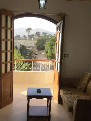 a living room with a couch and an open door at The Brown House in Luxor