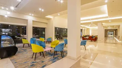 a lobby with colorful chairs and a table in a building at Amarina Abu Soma Resort & Aquapark in Hurghada