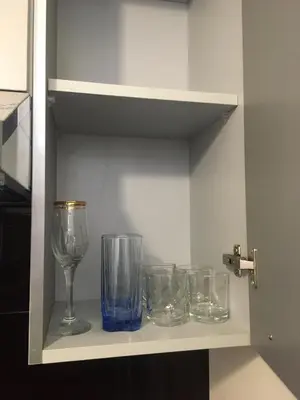 a row of glasses sitting on a shelf at One bedroom Apt at The View - B104 in Hurghada