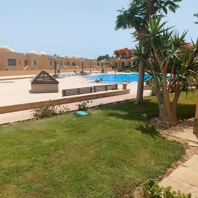 a park with a bench and a swimming pool at One bedroom Apt at The View - B104 in Hurghada