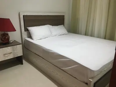 a bed with white sheets and a red lamp on a table at Sea View One Bedroom in Hurghada - H105 in Hurghada