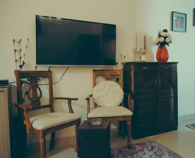 a living room with two chairs and a flat screen tv at Studio at Hurghada- NS2 in Hurghada
