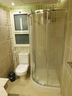 a bathroom with a toilet and a glass shower at Elite Suites Hurghada in Hurghada