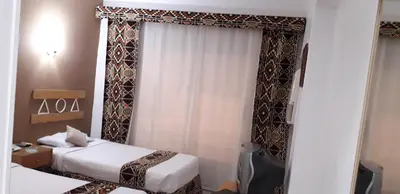 a hotel room with two beds and a window at Marhaba Palace Hotel in Aswan