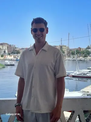 a man wearing sunglasses is standing on a dock at NiLe ViEW RANA NUbian Guest HOUES in Aswan