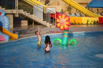 two children playing in the water at a swimming pool at Imperial Shams Abu Soma in Hurghada