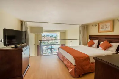 a hotel room with a bed and a flat screen tv at Imperial Shams Abu Soma in Hurghada