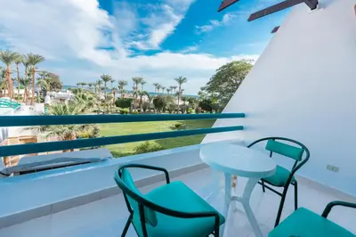 a balcony with chairs and a table and a view of the beach at Shams Safaga Resort in Hurghada