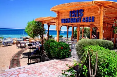 a restaurant with a sign on the beach at King Tut Aqua Park Beach Resort in Hurghada
